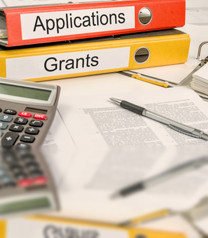 Grant and application binders on a working desk