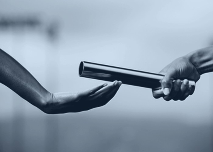A relay runner passing the baton
